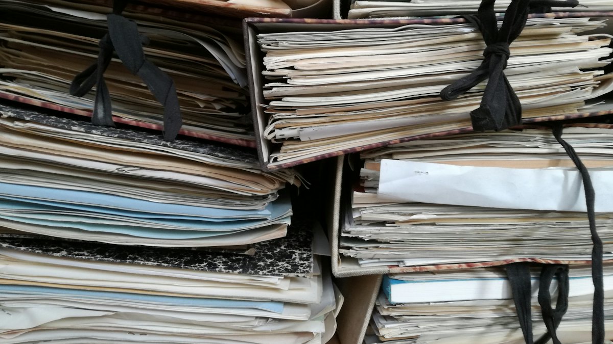 Pilhas de pastas de papel antigas amarradas com cordão em um arquivo